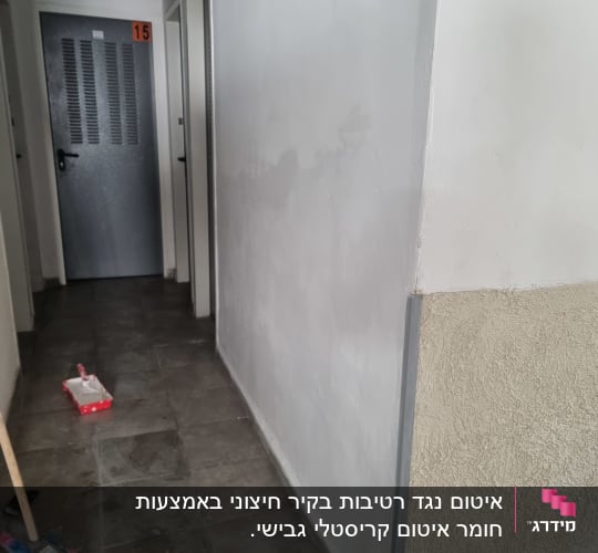 מסדרון עם קיר מטויח וכלי עבודה לאיטום
